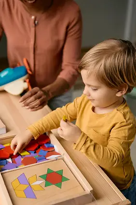 Small boy playing with wooden puzzle shapes with h 2024 12 13 19 35 35 utc.png